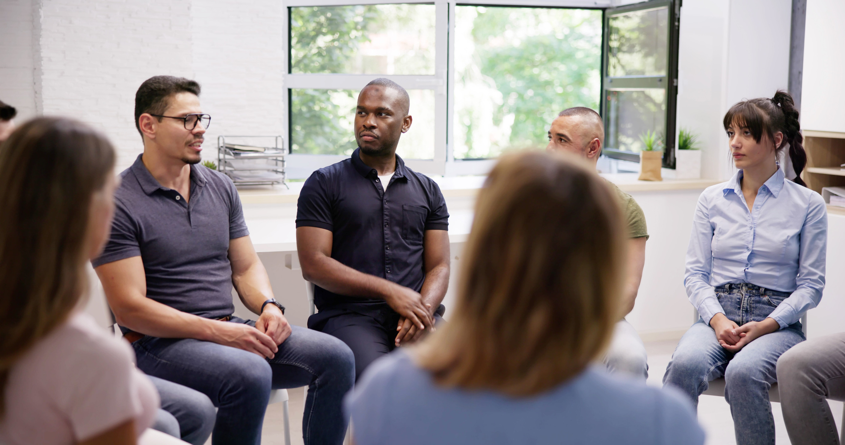 Supportive group sitting together by a window